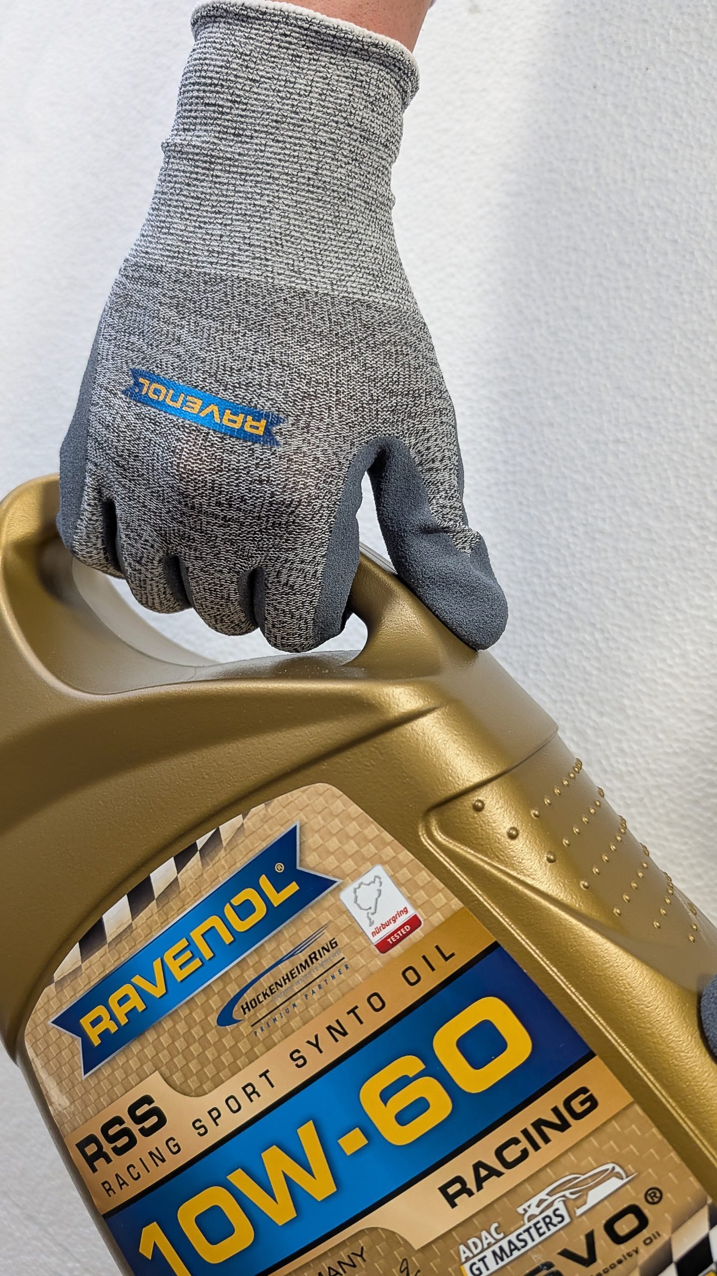 Guantes RAVENOL sosteniendo una garrafa